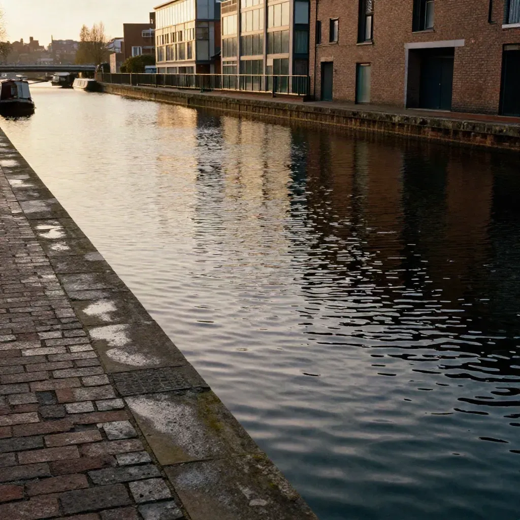 Birmingham canal basin at sunset with brick-and-glass frontage and calm reflective water